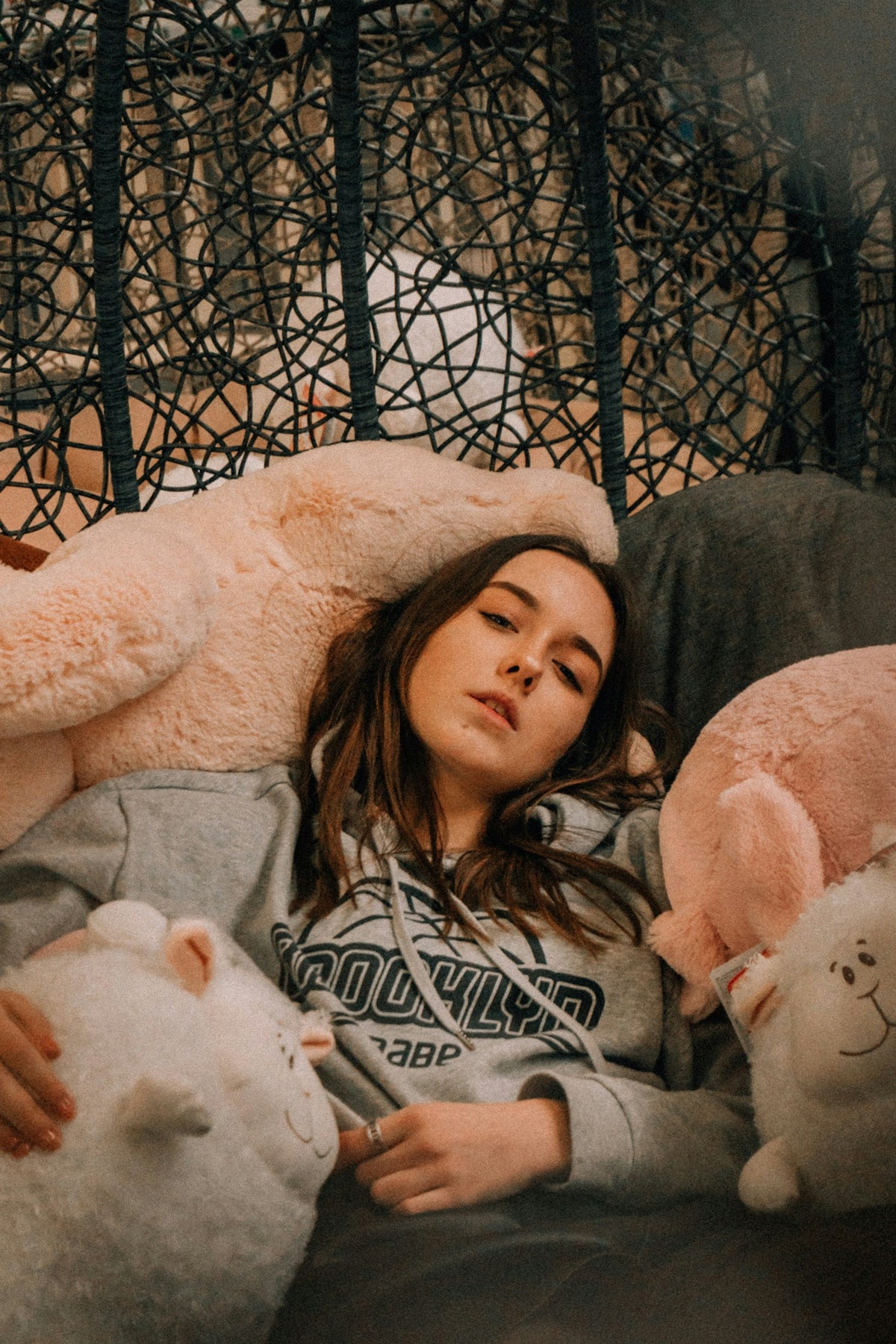 girl in white and black sweater sitting beside white bear plush toy