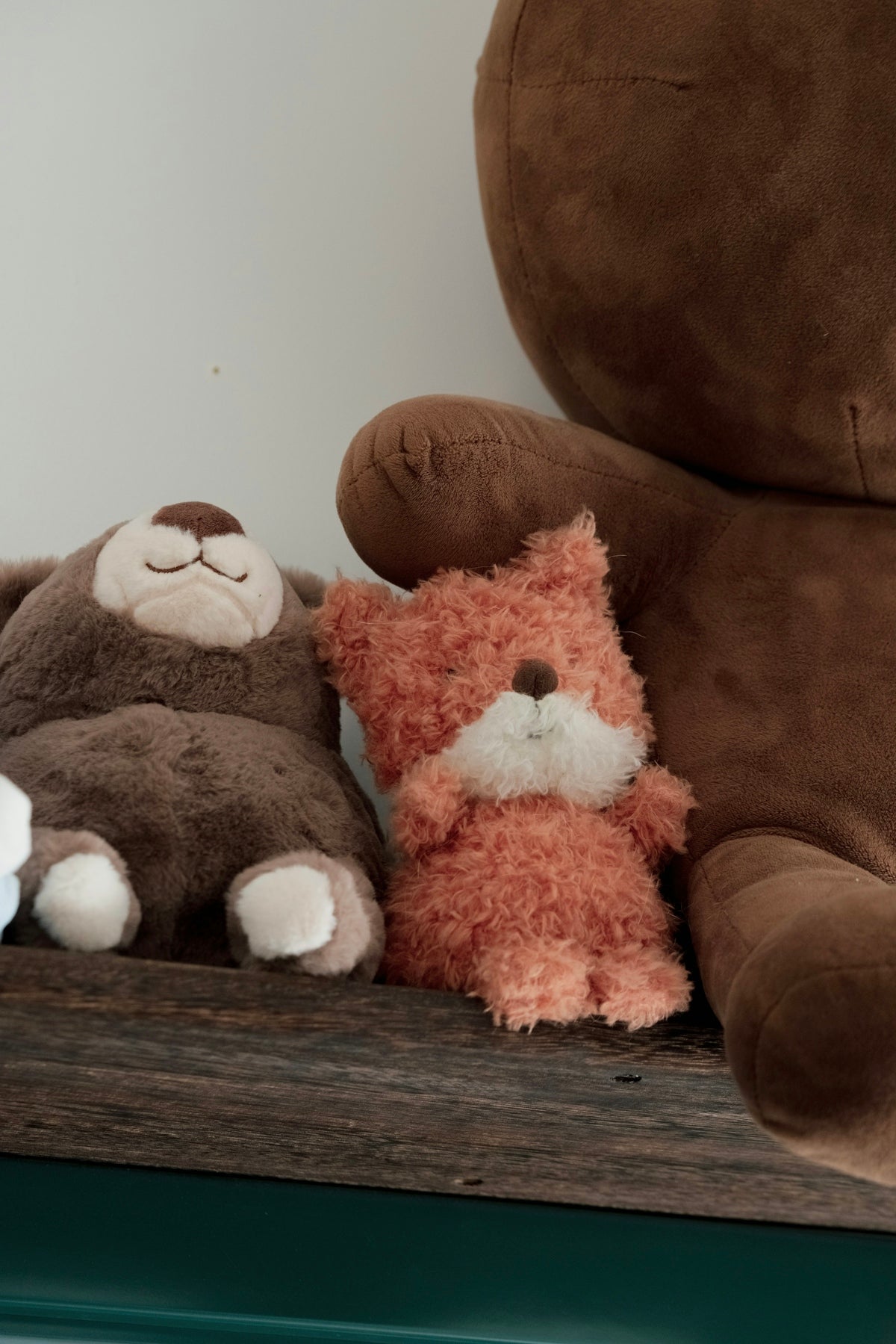 Three plush stuffed animals sit side-by-side.
